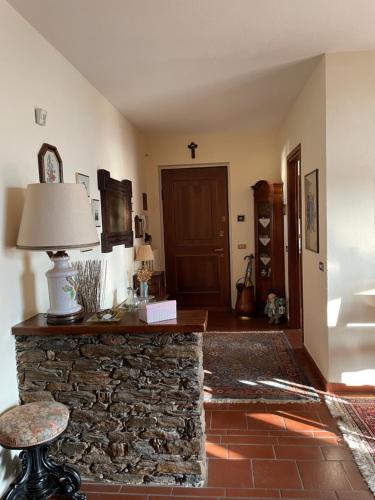 - un salon avec une cheminée en pierre et une lampe dans l'établissement B&B Gli Ulivi, à Carlazzo