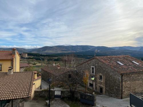 a view of some buildings with mountains in the background at Mirasierra II Y III in Navarredonda de Gredos