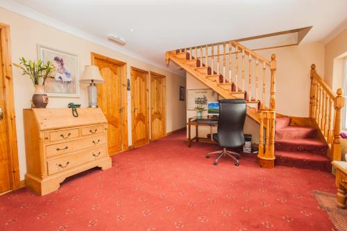 a room with a staircase and a desk and a chair at Sunville Bed And Breakfast in Ballycotton