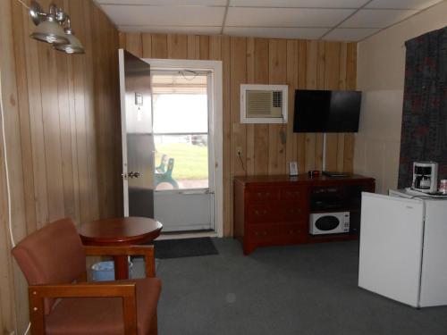 a living room with a refrigerator and a television at Aquarius Motel in Perth