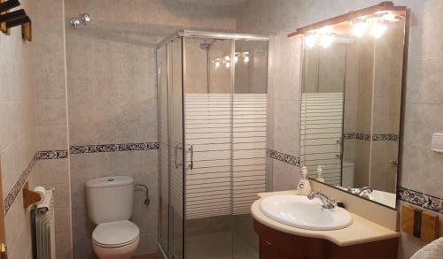 y baño con ducha, aseo y lavamanos. en Casa Castel Turismo Rural, en Serrate
