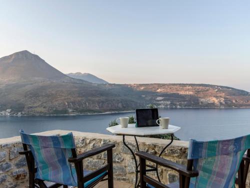 a table and two chairs with a laptop on a balcony at Selana View in Karavostasion