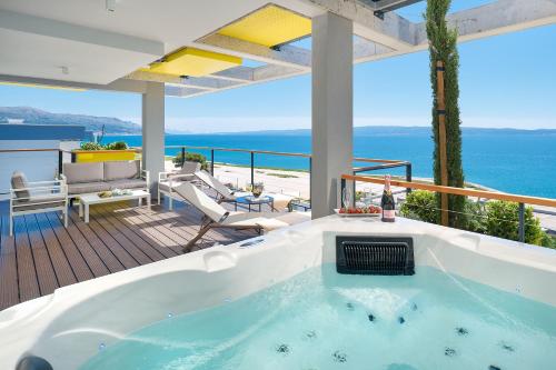 a hot tub on a deck with a view of the ocean at Amphora's Garden in Split