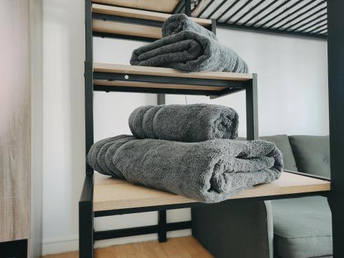 une pile de serviettes assises sur une étagère en bois dans l'établissement Joli Studio - Promenade des Anglais - Accès plage, à Nice