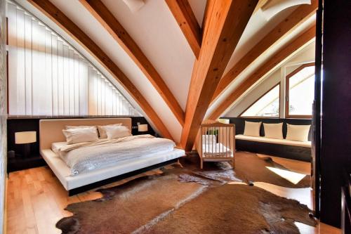 sypialnia z łóżkiem w pokoju z drewnianym sufitem w obiekcie Apartment Okružní w Szpindlerowym Młynie