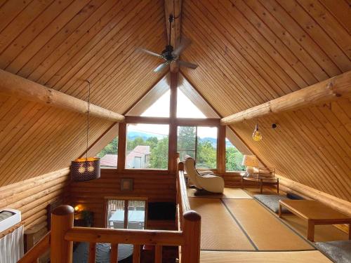 a room with a ceiling fan in a wooden house at A Private Log House with Mt Fuji View & Piano - "Thangtong House Japan" in Kannami