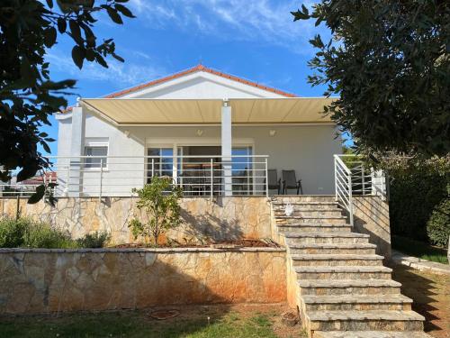 a white house with stairs in front of it at Seaside House PuntaSkala in Petrcane
