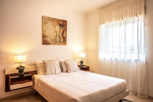 a bedroom with a large bed and a window at Casa da Praia in Ericeira