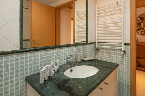 a bathroom with a sink and a mirror at Casa da Praia in Ericeira
