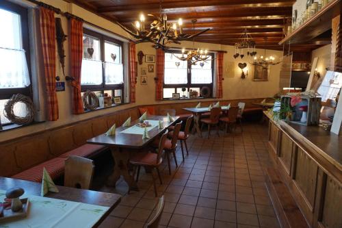 a restaurant with wooden tables and chairs and windows at Gasthof Zum Löwen in Mespelbrunn