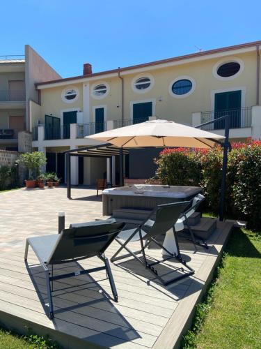 a patio with a table and an umbrella and chairs at Il Cavaliere Bed and Breakfast in Caserta