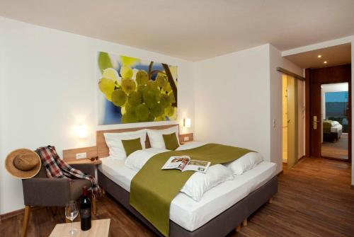ラウダ・ケーニヒスホーフェンにあるBENZ Weingut & Weinhotelのベッドルーム1室(壁に絵画が描かれたベッド1台付)