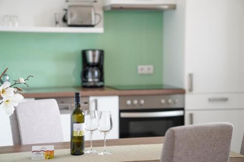 a bottle of wine sitting on a table with two wine glasses at BENZ Weingut & Weinhotel in Lauda-Königshofen