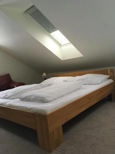 a bedroom with a large bed with a skylight at Apartments Villa Viola in Kovářská