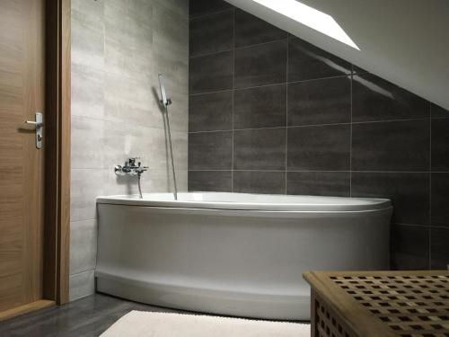 科瓦斯卡的住宿－Apartments Villa Viola，浴室设有白色浴缸和灰色瓷砖。
