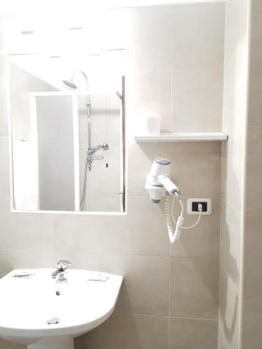 a white bathroom with a sink and a mirror at H&L Hotel in Cinisello Balsamo