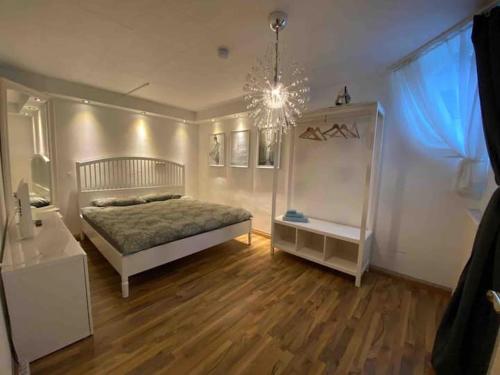 a bedroom with a bed and a chandelier at Tübingen Denzenberg / MIT GARTEN / FREE Parking in Tübingen