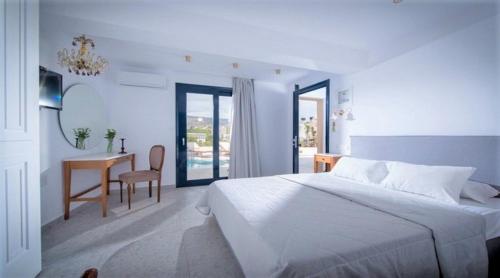 a white bedroom with a bed and a desk at Residence Villas by Estia in Stalida