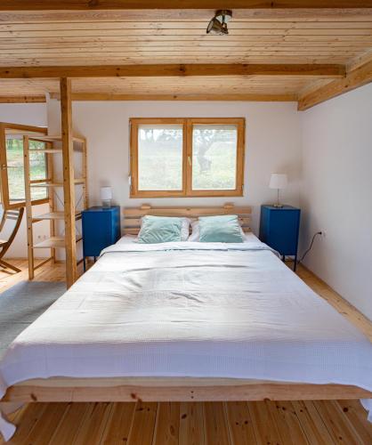 a large bed in a room with two blue tables at Rustic&Green Guesthouse for 6 people FREE AIRCONDITIONER FREE COFFEE FREE PARKING in Balatonkenese