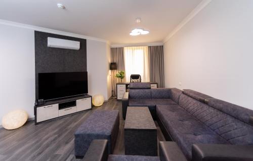 a living room with a couch and a flat screen tv at Downtown Suites Yerevan in Yerevan