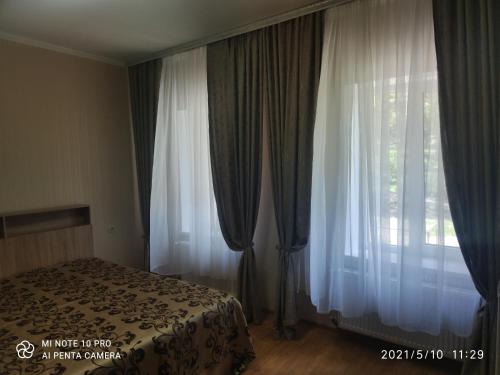 ピャチゴルスクにあるДом в курортной зонеのベッドルーム1室(ベッド1台付)、窓(カーテン付)