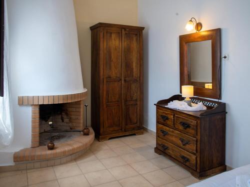 a bedroom with a fireplace and a dresser and a mirror at Selana View in Karavostasion