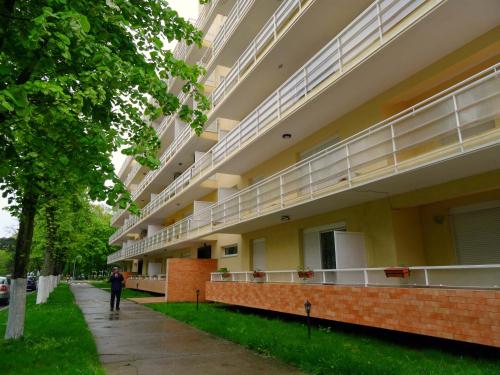 un edificio con balcones y una persona caminando por una acera en Club Onix Apartments, en Neptun