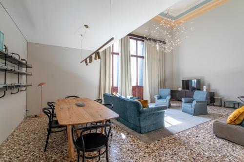 een woonkamer met een tafel en stoelen en een bank bij Infinite House Ca' Vendramin in Venetië