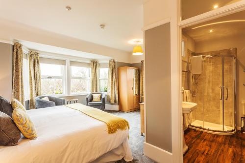 a bedroom with a bed and a shower and a bathroom at Aquila Heights Guest House in Dorchester