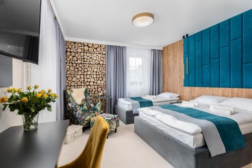 a hotel room with two beds and a table at Zamkowe Apartamenty in Sandomierz