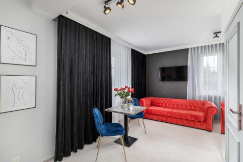 a living room with a red couch and a table at Zamkowe Apartamenty in Sandomierz