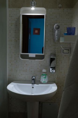 a bathroom with a sink with a tv on the wall at Bed & Breakfast Il Golfo in Naples