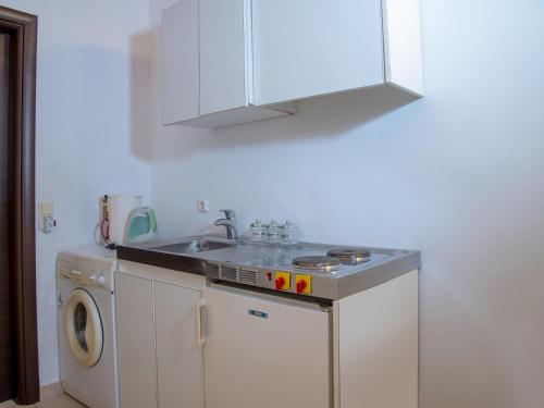 a kitchen with a sink and a washing machine at Selana View in Karavostasion