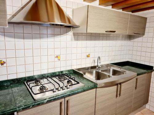 eine Küche mit einem Kochfeld und einem Waschbecken in der Unterkunft Casa Colonna in Montegrotto Terme