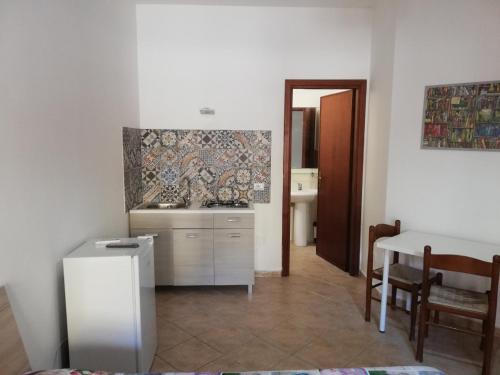 cocina con fregadero y mesa en una habitación en Callipigia, en Marsala