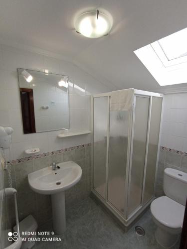 a bathroom with a shower and a sink and a toilet at Pensión O Escondidino in Baiona