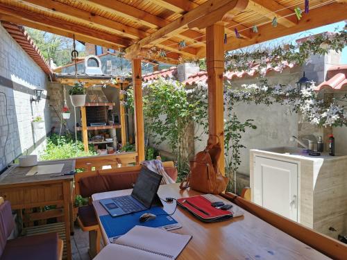 a patio with a table with a laptop on it at Rose valley guest house in Kazanlŭk