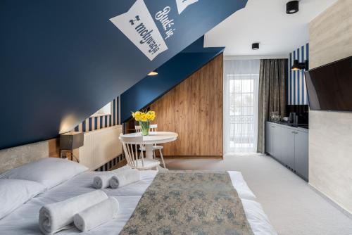 a bedroom with a bed and a blue wall at Zamkowe Apartamenty in Sandomierz