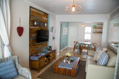 a living room with a couch and a table at Mylas Cottage in Swakopmund