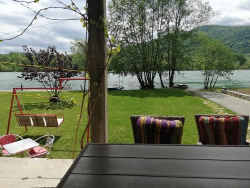 a patio with chairs and a view of a lake at Vikendica Marija, Culine in Mali Zvornik