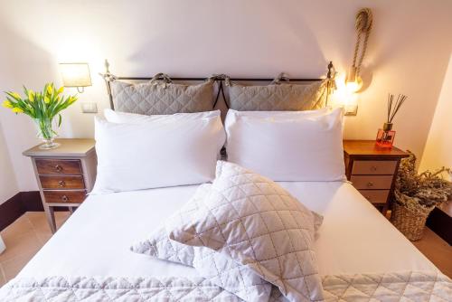 a bedroom with a bed with white sheets and pillows at Ex Convento Santa Croce-Country resort in SantʼAnatolia di Narco