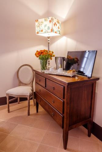 a desk with a lamp and a chair with flowers on it at Ex Convento Santa Croce-Country resort in SantʼAnatolia di Narco