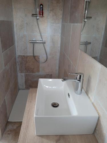 une salle de bain avec un lavabo blanc et une douche dans l'établissement LES CYPRES, à Maillane