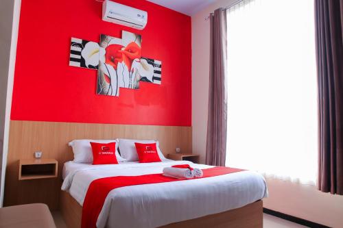 Camera rossa con letto a parete rossa. di D'SHARIO Hotel Kepanjen a Malang