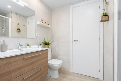 uma casa de banho branca com um WC e um lavatório em M A R I V E N T Private Terrace em Roses
