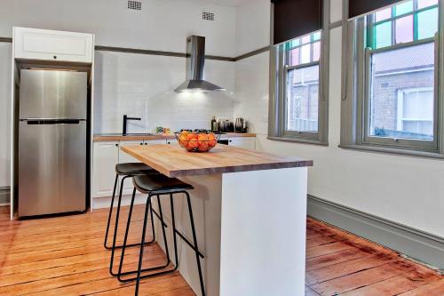 a kitchen with a counter with a bowl of fruit on it at Elements Of Goulburn in Goulburn