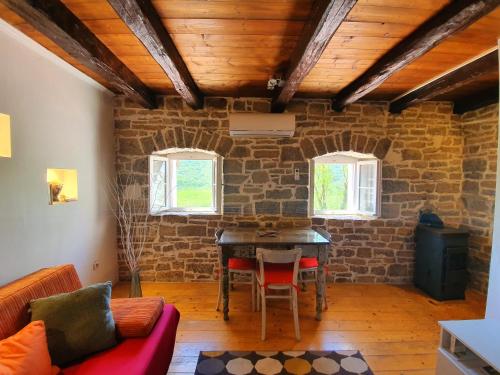 una sala de estar con una mesa en una pared de ladrillo en Casa Leonarda, old authentic Istrian stone house near Motovun, central Istria en Zamask