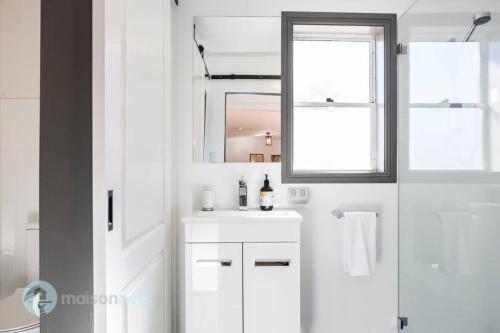 a white bathroom with a sink and a mirror at Elements Of Goulburn II in Goulburn