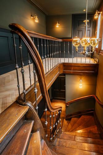 a staircase in a house with a chandelier at Boutique Hotel The Noblemen in Amsterdam