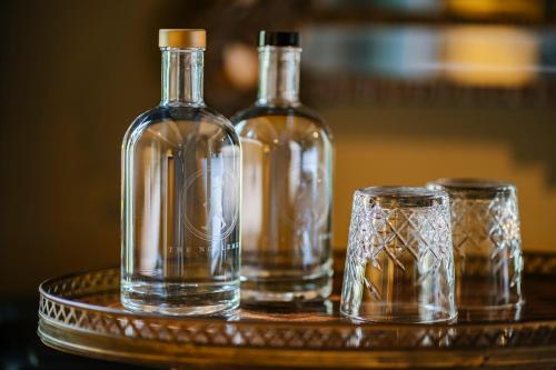 two bottles and two glasses on a table at Boutique Hotel The Noblemen in Amsterdam